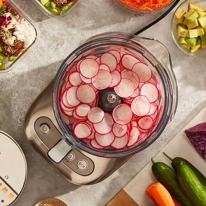 Close-up of Breville food processor attachment creating precise, even slices of vegetables.