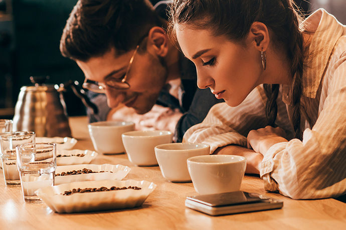a man and woman smelling the aroma of fresh coffee