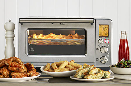 the Smart Oven® Air Fryer on bench with delicious food