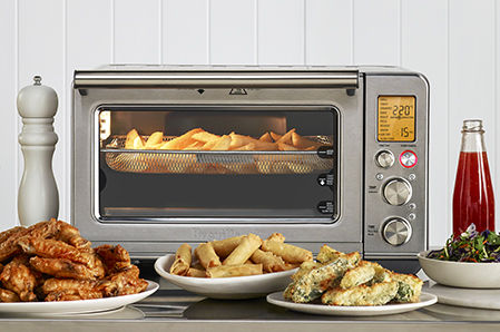 the Smart Oven® Air Fryer on bench with delicious food