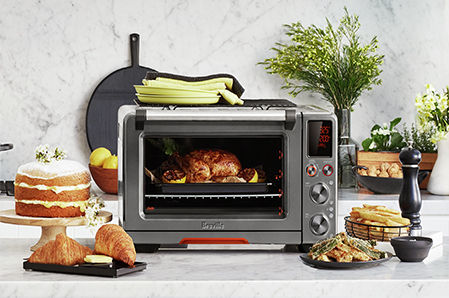 the Joule® Oven Air Fryer Pro sur banc avec de la nourriture délicieuse