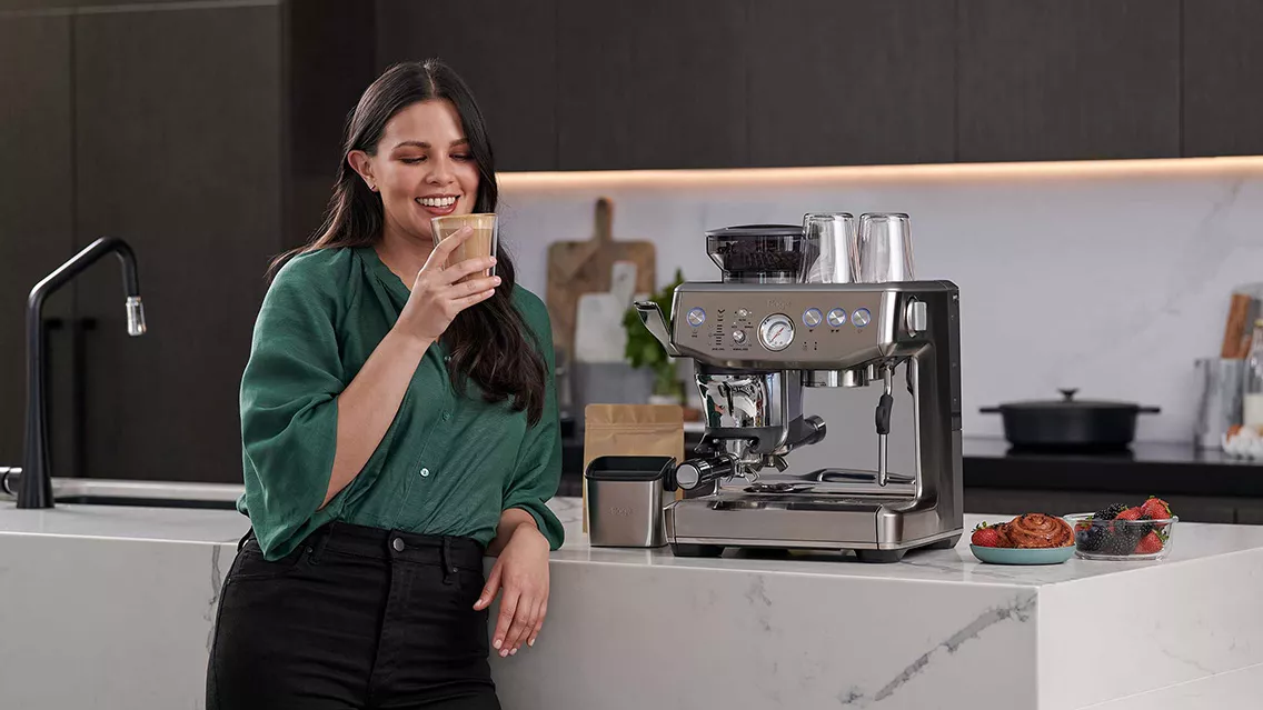 Woman standing next to the Barista Express Impress.