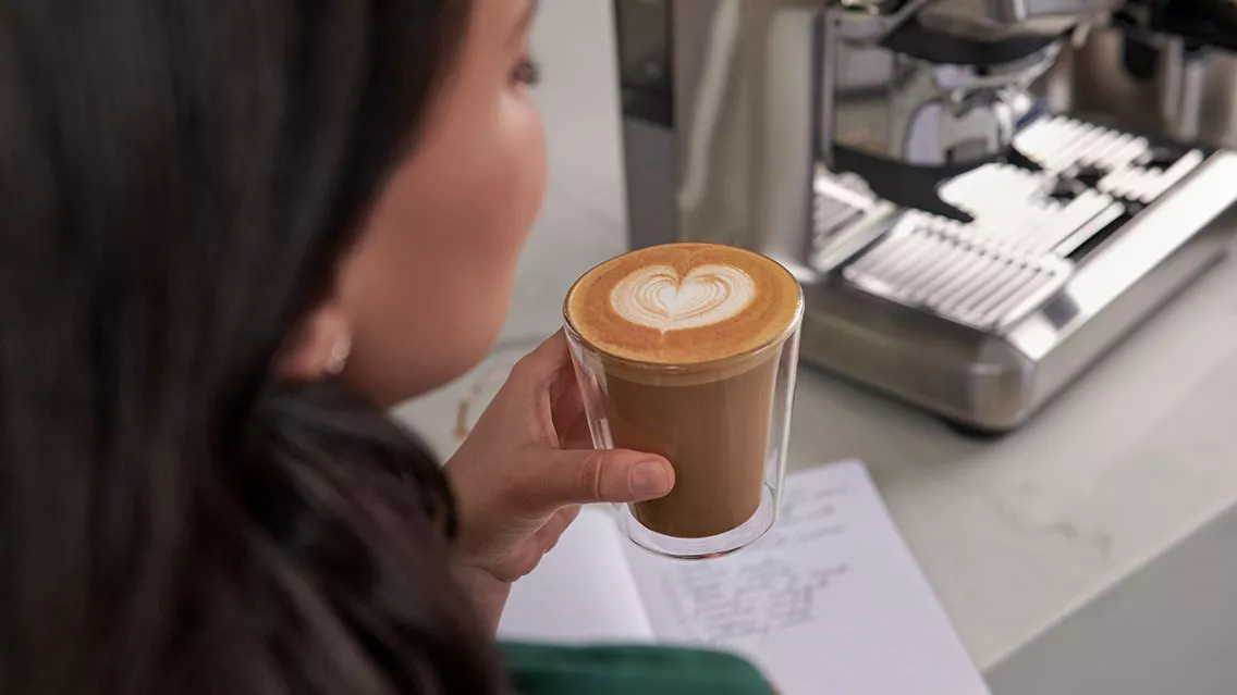 Woman holding a cup of latte art coffee.