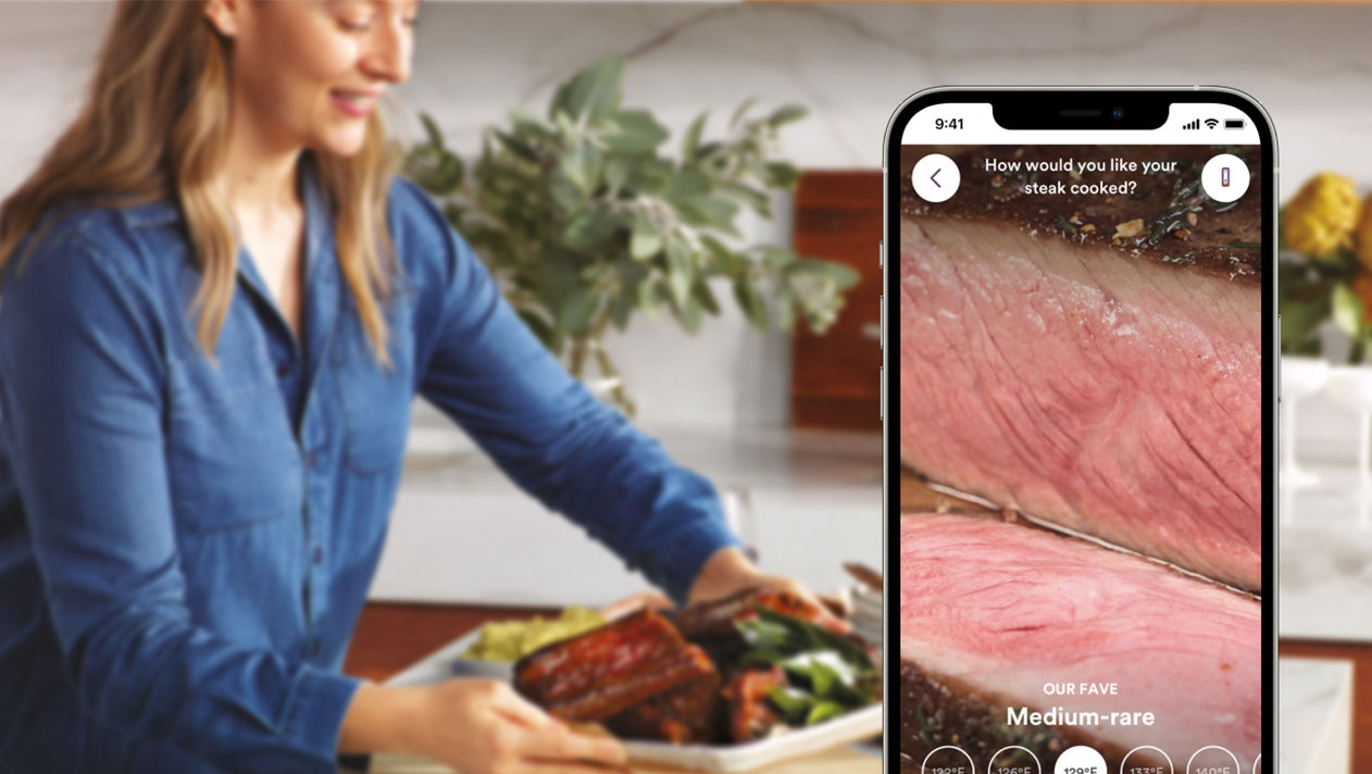 Woman holding a phone displaying Medium Rare on the screen