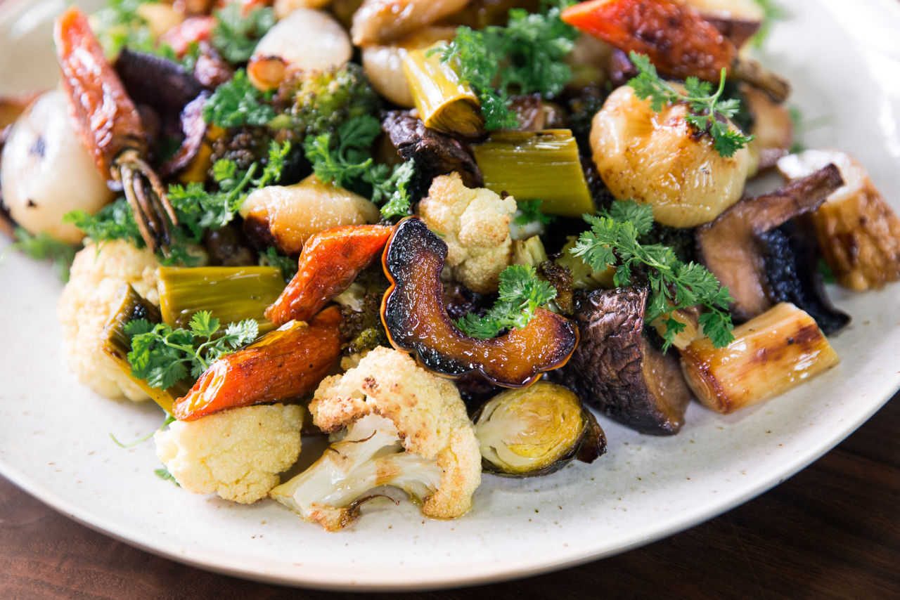 A plate of roasted zucchini, cauliflower, squash, and carrots. 